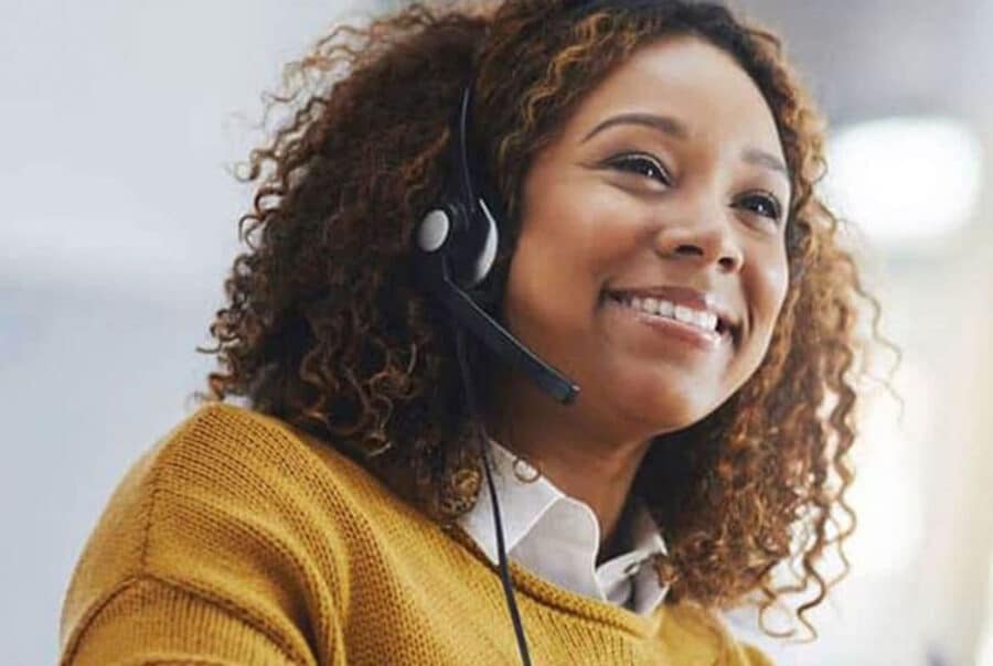Lady in office wearing yellow smiling.