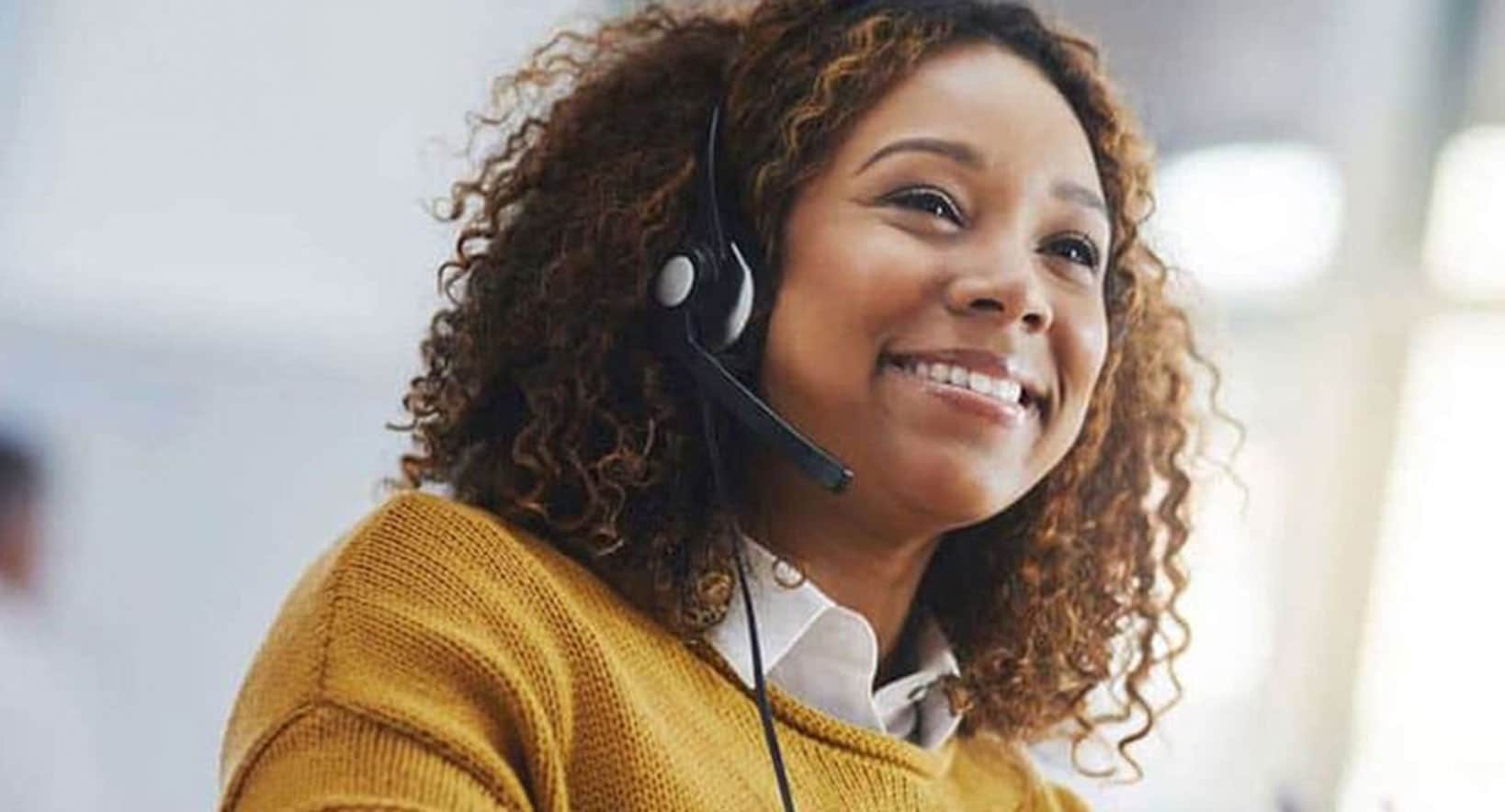 Lady in office wearing yellow smiling.