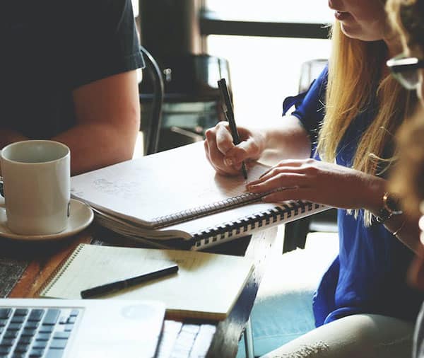 People sitting at a desk taking notes.