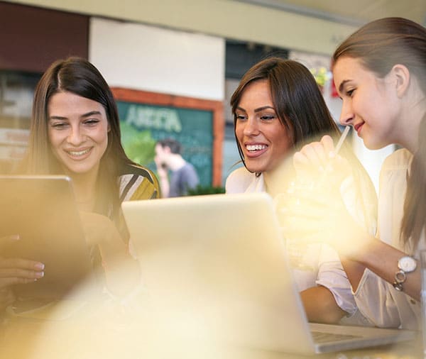 Three-ladies-sat-in-office-looking-at-hand-held-tablet